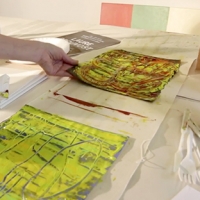 my hand is lifting a wet painted paper so it will not stick to the paper below